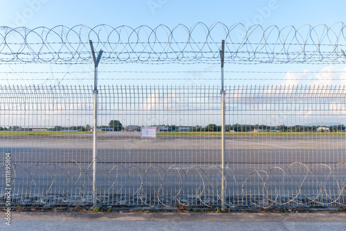 Fotografija Barbed wire fence or wall located around forbidden area or zone of airfield at t