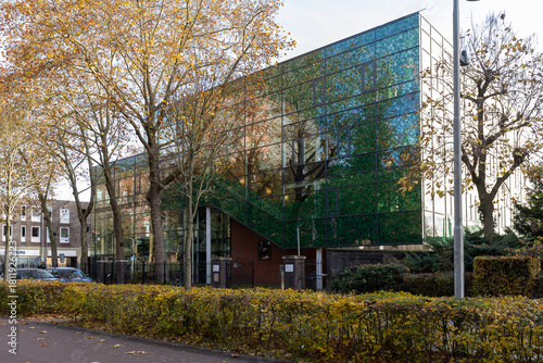 Tilburg, Netherlands - October 17, 2025: Modern business real estate offices in Dutch town seen through autumn coloured trees