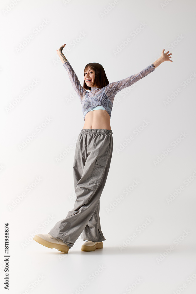 Obraz premium Stylish young woman exudes joy and confidence in contemporary fashion