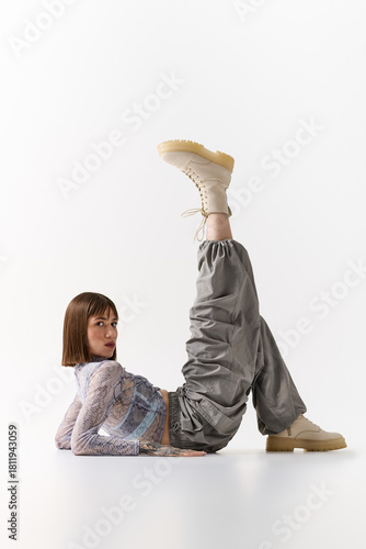 Stylish young woman poses creatively on a clean background at a fashion shoot