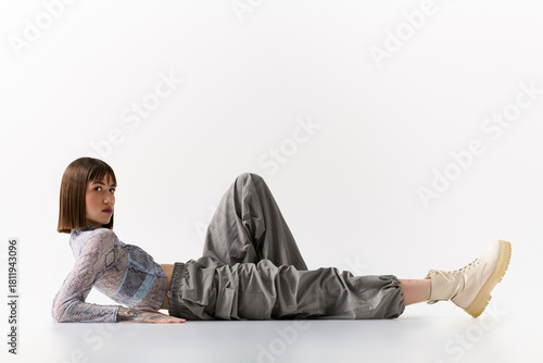 Confident young woman showcases modern fashion in a minimalist studio setting with elegance