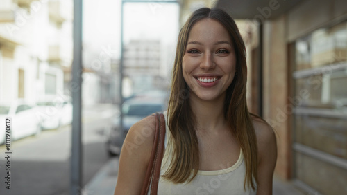 Hispanic woman smiles with exposed shoulder and looks to the right on a city street; optimism. Free Download Hispanic woman smiles with exposed shoulder and looks to the right on a city street; optimism. - GFXLoad