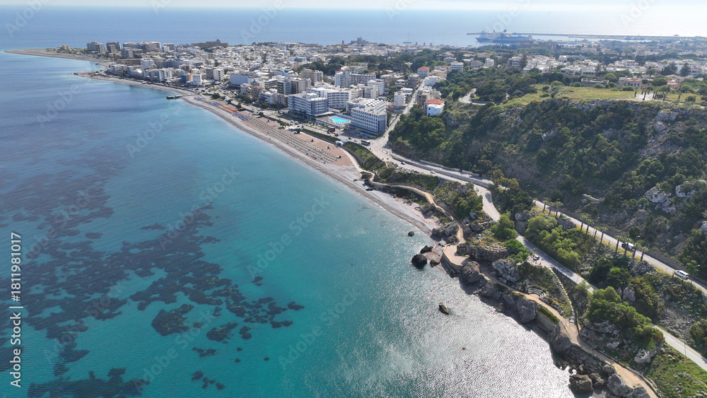 Fototapeta premium Aerial drone photo of beautiful beach with wonderful seaside promenade of Kato Petres featuring Cave Archangel Michael Panormitis, Rhodes island, Dodecanese, Greece