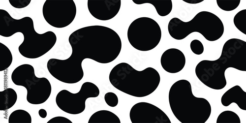 Seamless abstract monochrome pattern of organic black shapes and circles on a clean white background, resembling cow spots or dalmatian print, ideal for design.