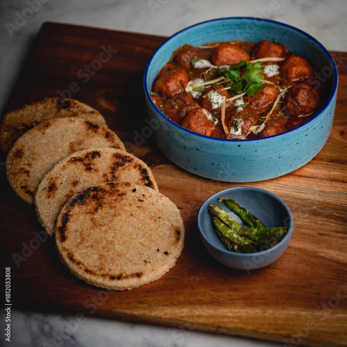 Thick, hard flatbread served alongside rich, aromatic korma—an indulgent pairing from traditional Indian cuisine.