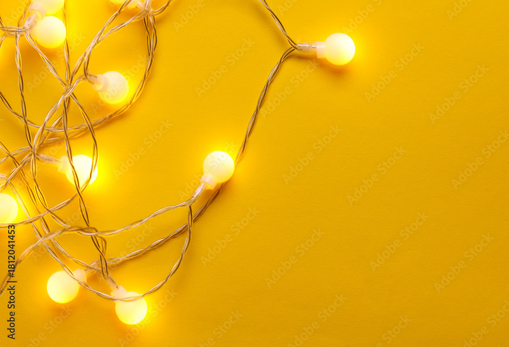 Obraz premium Glowing balls led garland on yellow background