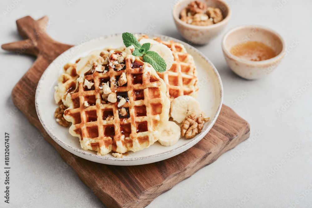 Naklejka premium Homemade waffles with topping of honey, walnut and banana