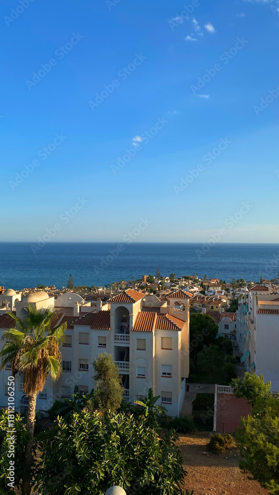 Obraz premium Malaga, Spain - August 15, 2022: Scenic view of Mediterranean coast in southern Spain with white buildings and palm trees under clear blue sky