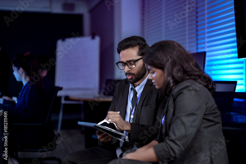 In a future marketing hub, a strategist uses a tablet to fine-tune a generative AI, creating a hyper-personalized ad campaign in real-time based on predictive analytics.