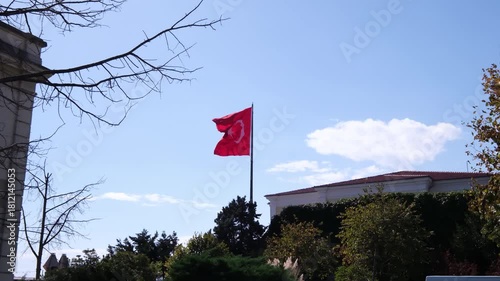 The footage features a vibrant Turkish flag waving prominently under a clear blue sky, symbolizing national pride and identity in an open landscape.
