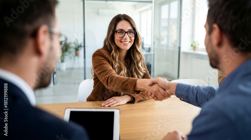 Smiling Young Female Candidate Shaking Hands With Hiring Manager After Successful Job Interview In Office