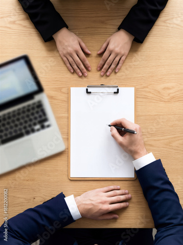 Top View Of Businessman Writing On Blank Clipboard Paper During Job Interview Meeting With Candidate