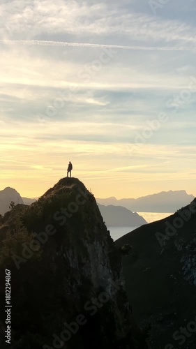 Man on top of a peak at sunset on the Stoos ridge hike with a stepped path in the foreground and a breathtaking sea of fog in beautiful autumn time