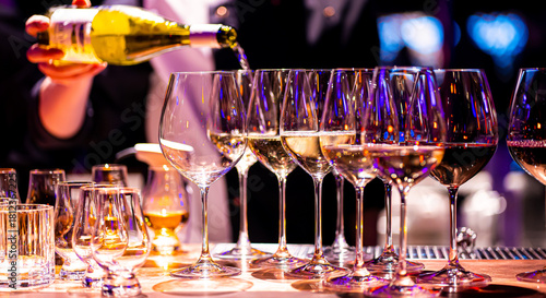 Waiter pouring wine into wineglass. Waiter work. Sommelier pours alcoholic drink