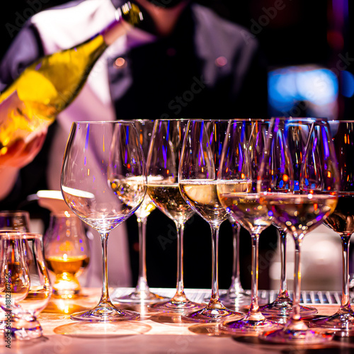 Waiter pouring wine into wineglass. Waiter work. Sommelier pours alcoholic drink