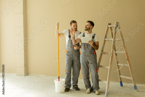 Two workers discussing plan...
