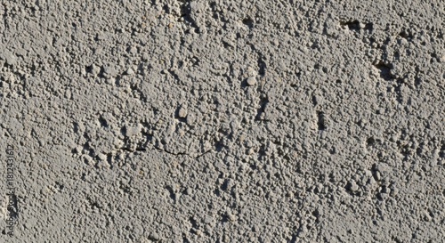 Closeup of a rough gray wall with a textured surface, showcasing its unevenness and rugged appearance in detail