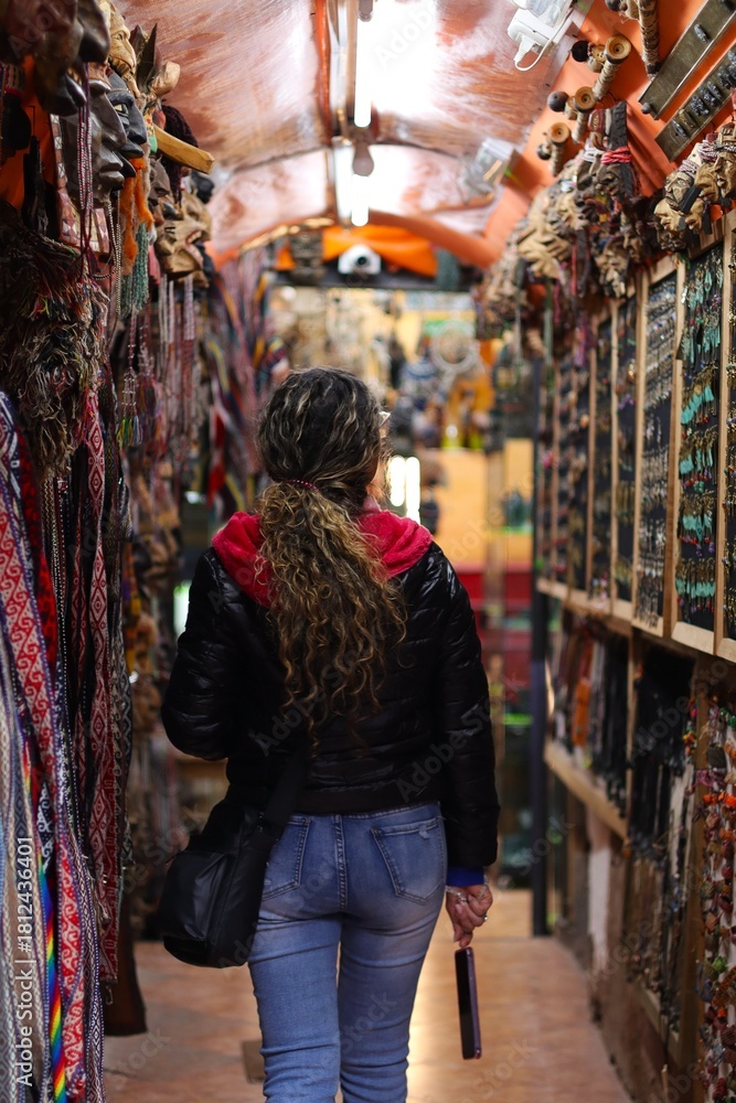 Obraz premium Young Woman Shopping for Handicrafts in Cusco