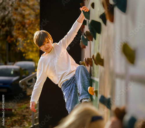 Teenager on a Climbing Wall. Outdoor Bouldering and Active Autumn Leisure.