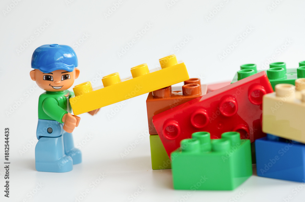 Naklejka premium Lego minifigure with colorful building blocks on white background. Lego is extremely popular worldwide with children and collectors.