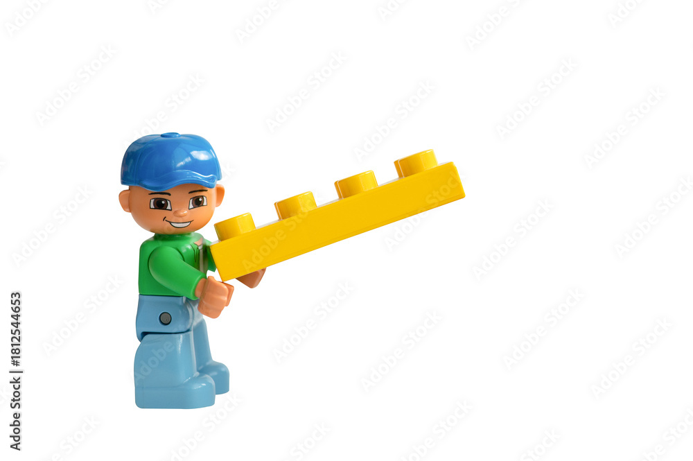 Naklejka premium A Lego Duplo man holding a Lego brick on a white background.