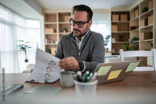 Man analyzing business charts working from home office