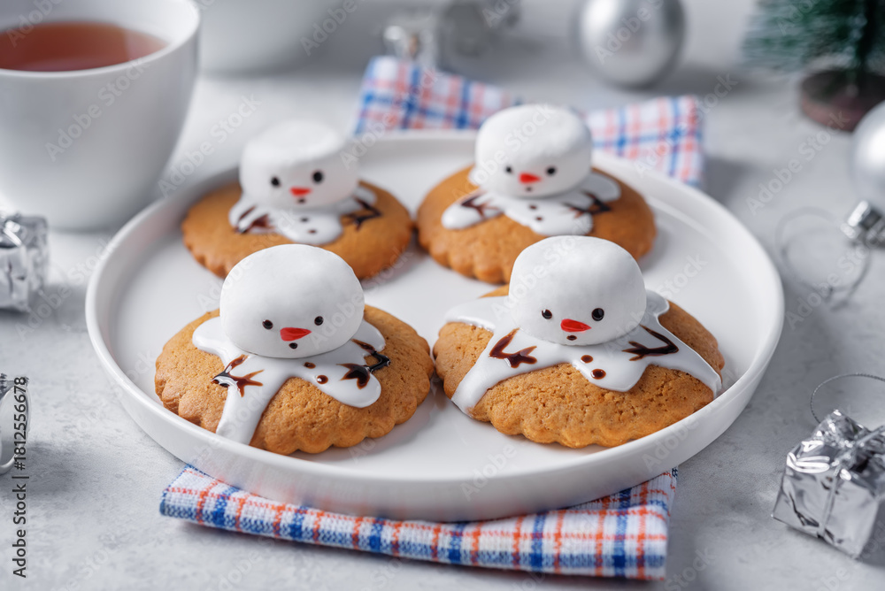 Fototapeta premium Gingerbread cookie with melting snowman topping on a white background