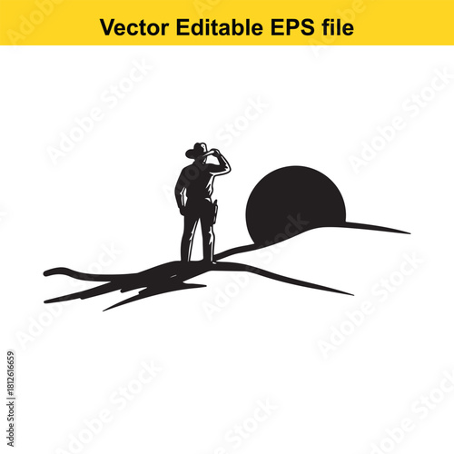 Silhouette of a cowboy wearing a hat standing on a desert dune looking at the setting or rising sun, isolated on