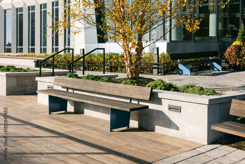 Fotografie Stylish outdoor seating area featuring modern benches and autumn foliage near a