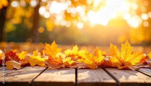 Autumn leaves on wooden table in warm sunlight