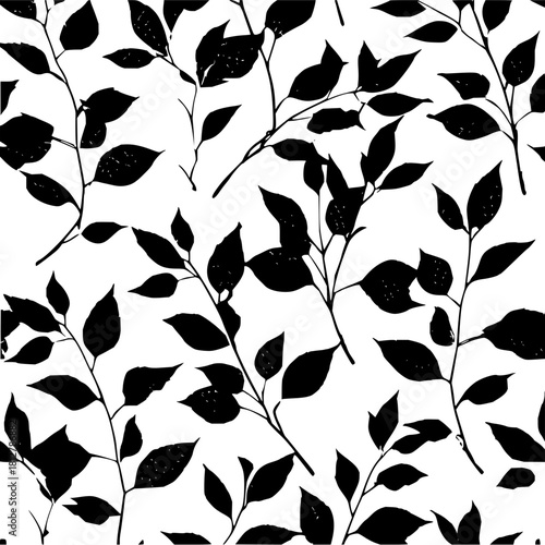 Seamless pattern of black foliage silhouettes against a white background creating a nature inspired design