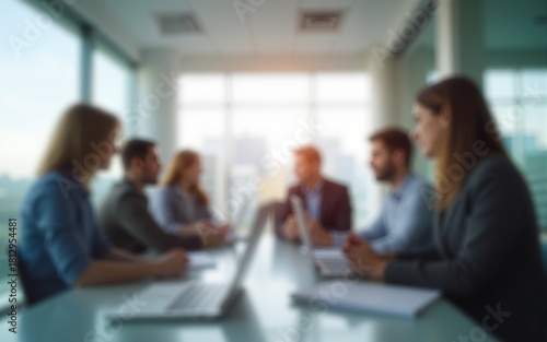 Blurred background of a modern office interior with blurred business people working in a team at a table. High quality