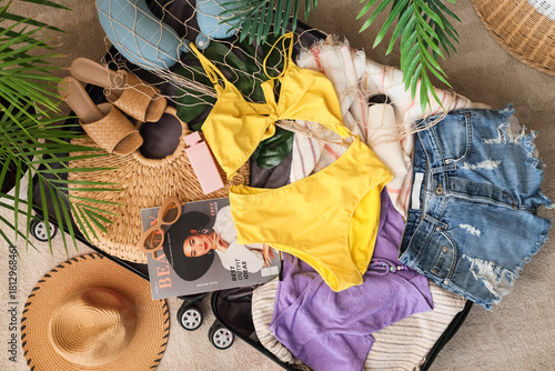 Open suitcase with beach ac...