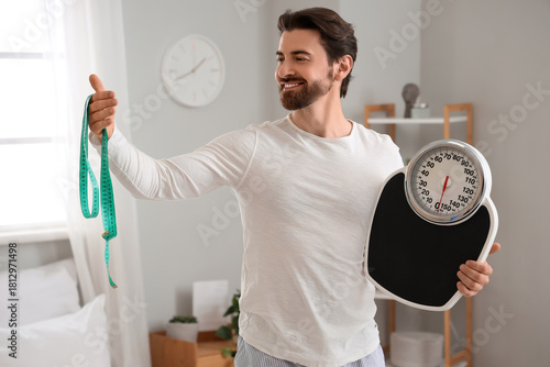 Young man with weight scale...