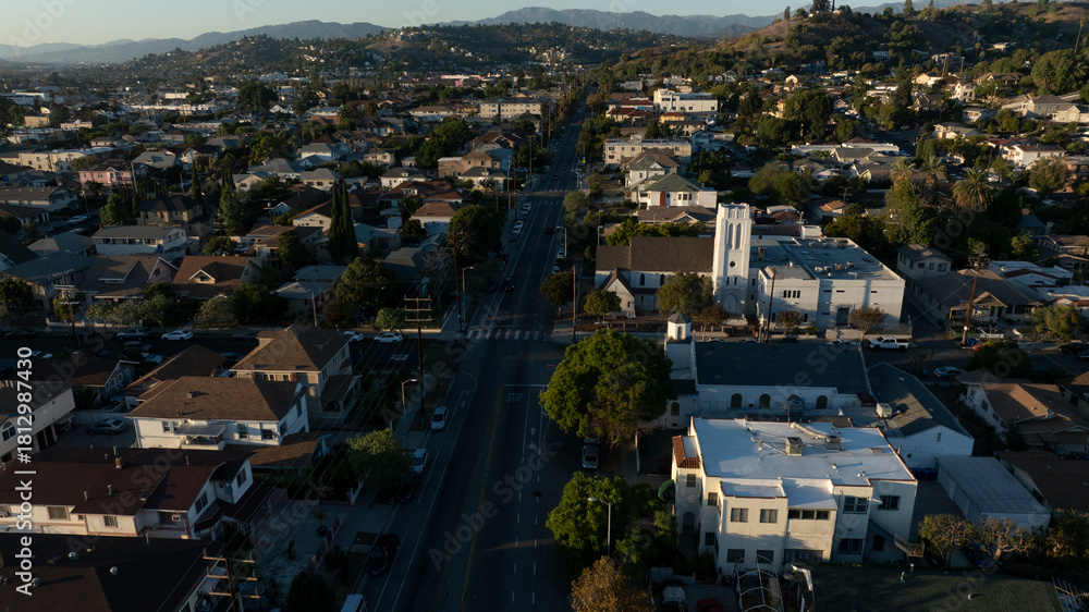 Obraz premium The sun sets on homes and a church in the historic Lincoln Heights neighborhood of Los Angeles, California, USA.