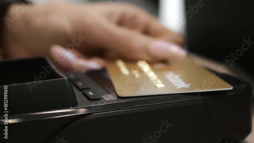 Close up hand making contactless card payment at POS terminal in retail store. Modern cashless transaction and secure banking technology indoors.