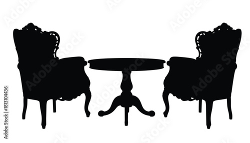 Silhouette of two ornate antique armchair chairs flanking a small round pedestal table