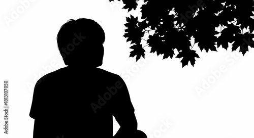 Silhouette of a person sitting under a tree.