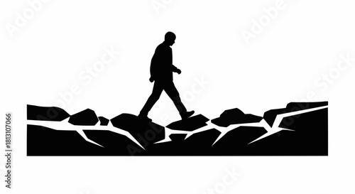 Silhouette of a person walking on rocks, navigating a challenging path.