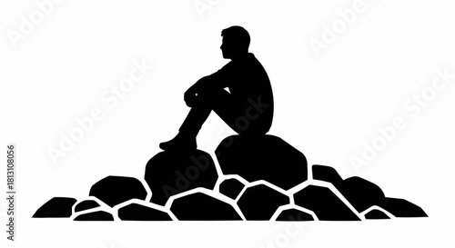 Silhouette of a man sitting on rocks, contemplating life and nature.