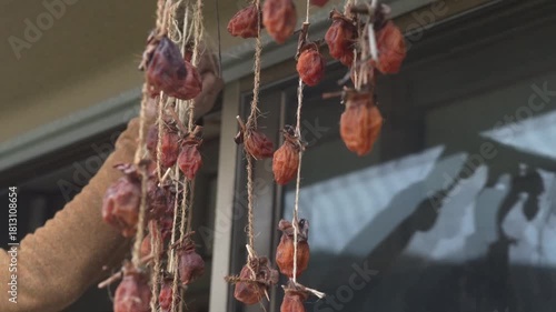 干し柿を取り込む男性