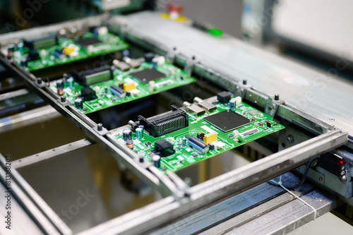 Electronic circuit boards moving along an assembly line at a manufacturing facility during daytime operations