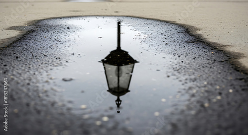 Reflection of Street Lamp in Puddle on Rainy Day Capturing Urban Serenity