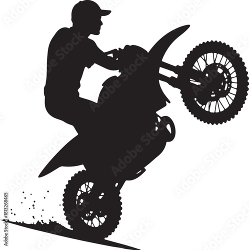 Black silhouette of a motocross rider performing a wheelie