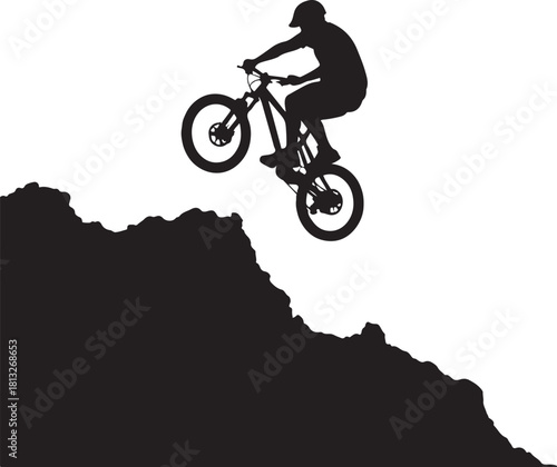 Black silhouette of a mountain biker jumping over a rocky cliff