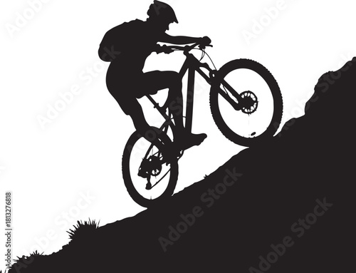 Silhouette of mountain biker riding downhill on rocky terrain