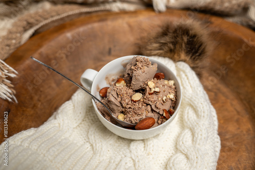 Bowl of chocolate almond ice cream in a bowl. Cozy setting.