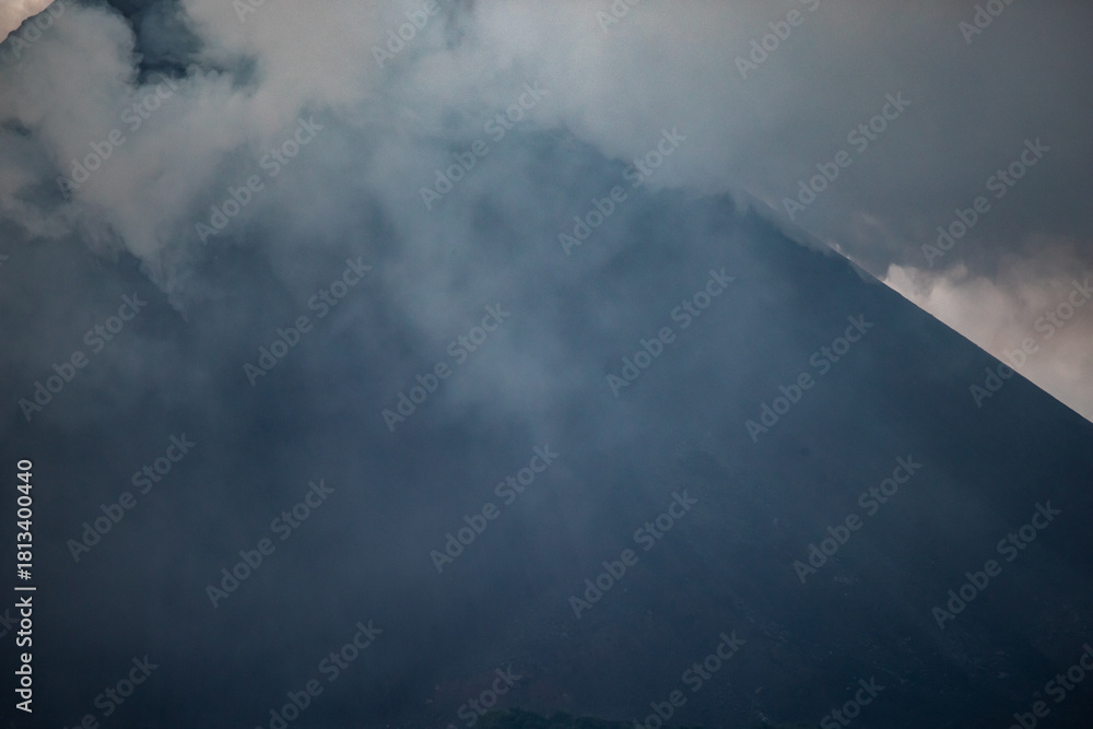 Fototapeta premium Barren Island Volcano Cone Peak Shrouded in Rising Smoke