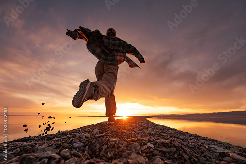 Young happy woman girl runs at sunset lake shore. Vacations near the water concept