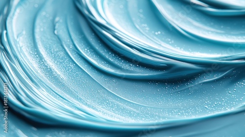 Swirled blue viscous liquid with glossy surface and tiny speckles; close-up macro view